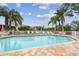 Community pool featuring a seating area surrounded by lush landscaping and inviting lounge chairs creating a serene escape at 11162 Kapok Grand Cir, Madeira Beach, FL 33708