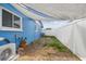 View of the backyard featuring white privacy fence, blue house, and partial sun shade at 11762 82Nd Ter, Seminole, FL 33772