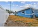 The backyard features a modern blue house, a white fence and ample space at 11762 82Nd Ter, Seminole, FL 33772