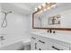 Bright bathroom with white vanity, decorative mirror, and shower/tub combo at 11762 82Nd Ter, Seminole, FL 33772