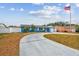 Delightful single-story home showcasing a curved driveway, vibrant blue exterior, and a waving American flag at 11762 82Nd Ter, Seminole, FL 33772