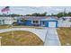 Inviting single-story home featuring a well-manicured lawn, charming blue exterior, and an American flag at 11762 82Nd Ter, Seminole, FL 33772