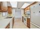 Efficient kitchen layout with wooden cabinets, white appliances, and a clear view into the adjacent living areas at 11762 82Nd Ter, Seminole, FL 33772
