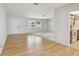 Open-concept living room featuring wood floors, white walls, and view to kitchen and front door at 11762 82Nd Ter, Seminole, FL 33772