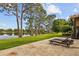Spacious backyard with lounge chairs, travertine pavers, and a serene lake view at 11817 Glen Wessex Ct, Tampa, FL 33626