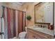 Bathroom with granite countertop vanity, framed mirror, decorative shower curtain and neutral wall texture at 11817 Glen Wessex Ct, Tampa, FL 33626