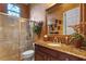 Elegant bathroom featuring a glass-enclosed shower, decorative mirror, and granite countertop vanity at 11817 Glen Wessex Ct, Tampa, FL 33626