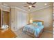 Cozy bedroom featuring a ceiling fan, closet, warm-toned walls and a colorful comforter at 11817 Glen Wessex Ct, Tampa, FL 33626