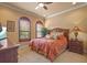 Comfortable bedroom featuring a decorative fan, wood furnishings, shuttered windows, and a tropical comforter at 11817 Glen Wessex Ct, Tampa, FL 33626