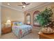 Charming bedroom with a ceiling fan, crown molding, shuttered windows and a large, vibrant floral comforter at 11817 Glen Wessex Ct, Tampa, FL 33626