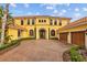 Stately two-story home with a red tile roof, arched windows, a brick driveway, and well-manicured landscaping at 11817 Glen Wessex Ct, Tampa, FL 33626