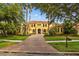 Luxurious two-story home with a red tile roof, arched windows, a brick driveway, and mature landscaping at 11817 Glen Wessex Ct, Tampa, FL 33626