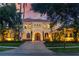Elegant two-story home with a red tile roof, arched windows, a brick driveway, and mature landscaping at 11817 Glen Wessex Ct, Tampa, FL 33626