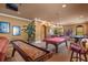 Large game room with a shuffleboard table, pool table, home theater, and bar seating at 11817 Glen Wessex Ct, Tampa, FL 33626