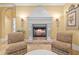Comfortable living room with a decorative fireplace, chairs, stone flooring, and elegant wall decor create an inviting atmosphere at 11817 Glen Wessex Ct, Tampa, FL 33626