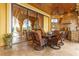 Covered patio features an outdoor kitchen, dining area, and serene lake view in the background at 11817 Glen Wessex Ct, Tampa, FL 33626