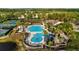 Community pool with a water slide surrounded by lush landscaping, tennis courts, and seating areas at 11817 Glen Wessex Ct, Tampa, FL 33626