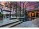 Screened-in pool area with a hot tub, patio furniture, travertine tile, and a view of the lake at sunset at 11817 Glen Wessex Ct, Tampa, FL 33626