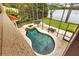 Aerial view of a backyard pool and spa with screened enclosure near a lake at 11817 Glen Wessex Ct, Tampa, FL 33626