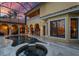 Inviting backyard pool area with a spa, covered patio, outdoor kitchen, columns, and travertine tile at 11817 Glen Wessex Ct, Tampa, FL 33626