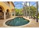 Expansive screened pool area featuring a spa, lounge chairs, and an outdoor bar with stunning waterfront views at 11817 Glen Wessex Ct, Tampa, FL 33626