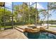 A luxurious screened pool area with a built-in spa, stylish patio furniture, and lush green landscaping for ultimate relaxation at 11817 Glen Wessex Ct, Tampa, FL 33626