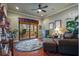 Relaxing sitting room with hardwood floors, a cozy couch, leafy plants and sliding glass door to a screened patio at 11817 Glen Wessex Ct, Tampa, FL 33626
