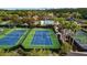 Aerial view of well-maintained tennis courts with professional surfacing and net, set in a landscaped community at 11817 Glen Wessex Ct, Tampa, FL 33626