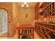 Spacious wine cellar with brick walls, wooden shelving, and a table for tastings and showcases a wide selection of wine bottles at 11817 Glen Wessex Ct, Tampa, FL 33626