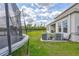 Backyard view showcases an installed trampoline and a manicured lawn, highlighting the property's leisure potential at 12710 Hysmith Loop, Parrish, FL 34219