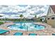 A sunny pool surrounded by lounge chairs with a view of the lake and neighborhood homes at 12710 Hysmith Loop, Parrish, FL 34219