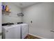 Bright laundry room features a washer, dryer, and shelving for ample storage and organization at 12710 Hysmith Loop, Parrish, FL 34219