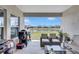Relaxing covered patio with wicker furniture, gas grill, and scenic views of the pond and backyard at 12710 Hysmith Loop, Parrish, FL 34219