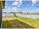 The backyard features a large area of grass and a playset and a community lake view at 13529 Wild Ginger St, Riverview, FL 33579