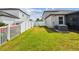Spacious backyard with green grass, white fence, swing and AC units at 13529 Wild Ginger St, Riverview, FL 33579
