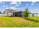 Expansive backyard featuring lush green grass, screened porch, and playful swing set at 13529 Wild Ginger St, Riverview, FL 33579