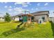 A backyard featuring a playground, slide, swing and plenty of space for activities at 13529 Wild Ginger St, Riverview, FL 33579