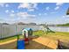 A fenced backyard featuring a playset, patio and beautiful view of the community lake at 13529 Wild Ginger St, Riverview, FL 33579