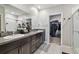 Bathroom featuring double sinks, granite countertops, and a walk-in closet for plenty of storage at 13529 Wild Ginger St, Riverview, FL 33579
