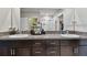 Bathroom featuring double sinks with granite countertops, dark cabinets, and large mirror at 13529 Wild Ginger St, Riverview, FL 33579