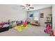 Neutral bedroom featuring a window, ceiling fan and ample toy storage at 13529 Wild Ginger St, Riverview, FL 33579