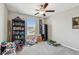Bedroom with neutral walls, a ceiling fan, and built-in shelving filled with books at 13529 Wild Ginger St, Riverview, FL 33579