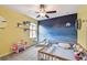 bedroom showcasing unique cloud shelves, a crib, and a star and moon themed accent wall at 13529 Wild Ginger St, Riverview, FL 33579