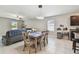 Open-concept dining area with stylish light fixture, tile floors and adjacent to living space and kitchen at 13529 Wild Ginger St, Riverview, FL 33579