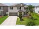 A two-story home showcasing its well-manicured lawn and attached two-car garage at 13529 Wild Ginger St, Riverview, FL 33579