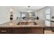 Kitchen island with dual sink and faucet, with a living and dining area visible in the background at 13529 Wild Ginger St, Riverview, FL 33579