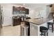 Kitchen showcasing dark cabinets, stainless steel appliances, and an island with barstool seating at 13529 Wild Ginger St, Riverview, FL 33579