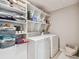 Bright laundry room with ample shelving, washer, and dryer at 13529 Wild Ginger St, Riverview, FL 33579