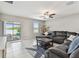 Comfortable living room features a ceiling fan, sliding glass doors to the patio, and a plush sectional sofa at 13529 Wild Ginger St, Riverview, FL 33579