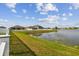 Beautiful backyard pond view framed by a white fence and vibrant green grass at 13529 Wild Ginger St, Riverview, FL 33579